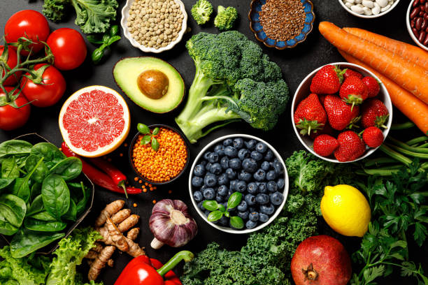 Colourful fresh vegetables and fruits arranged on a wooden table during a nutrition consultation